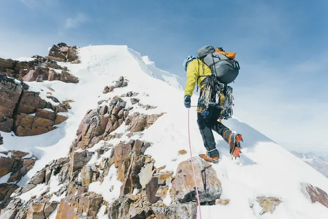 Alpiniste sur une arête enneigée