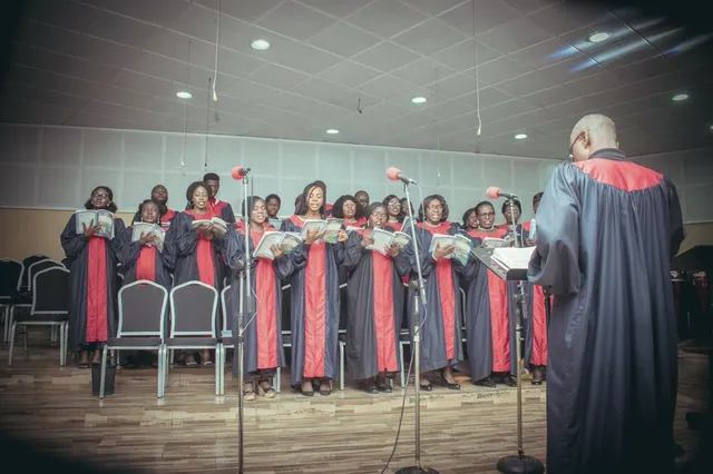 Chorale en robes sur scène, face à son chef de chœur