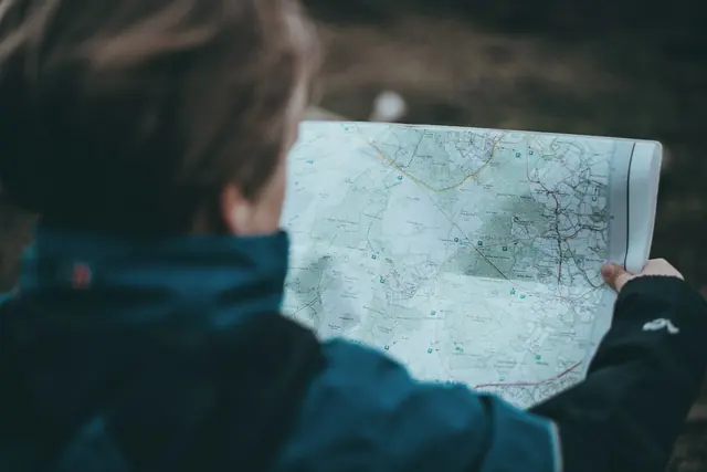 Orienteur qui lit sa carte en forêt