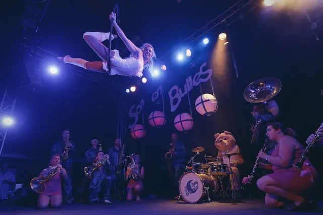 Acrobate sur un cerceau aérien au-dessus de musiciens, sur scène