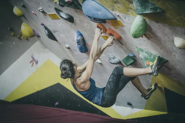 Grimpeuse sur un mur de bloc en salle