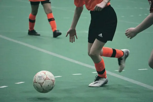 Ballon de futsal au pied d’un joueur en salle