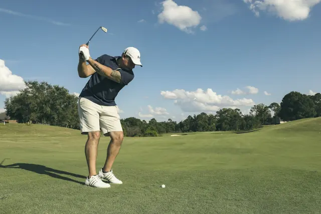 Golfeur en fin de swing sur le parcours