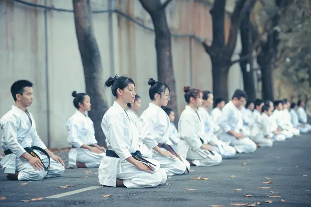 Karatékas en kimono alignés à genoux pour le salut
