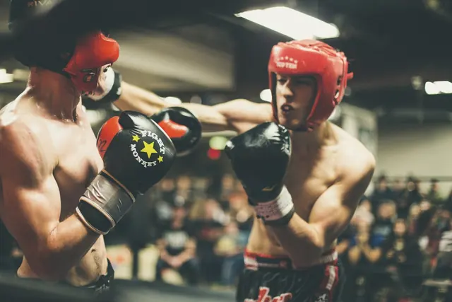 Deux combattants de kick-boxing casqués sur le ring