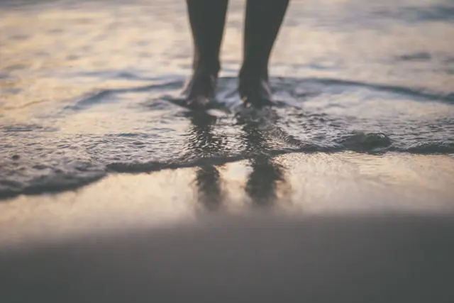Pieds dans les vagues au bord de la mer