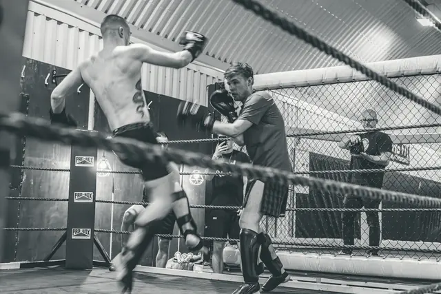 Combat d’arts martiaux mixtes dans une cage, en noir et blanc