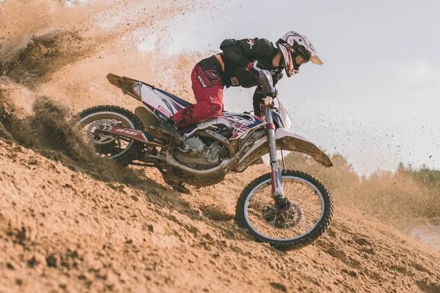 Pilote de motocross dans la poussière d’un virage