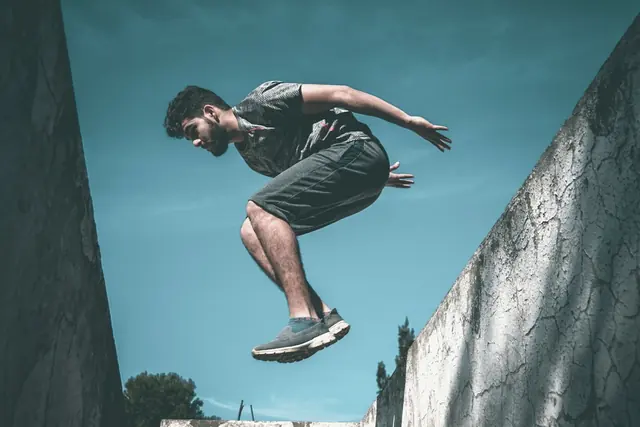 Traceur de parkour en saut entre deux murs