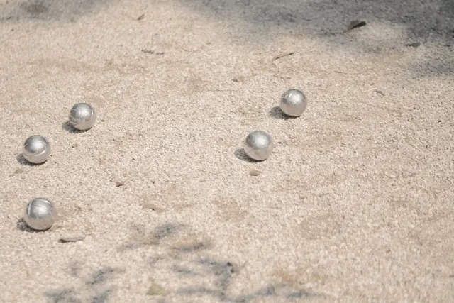 Boules de pétanque et cochonnet sur le sable