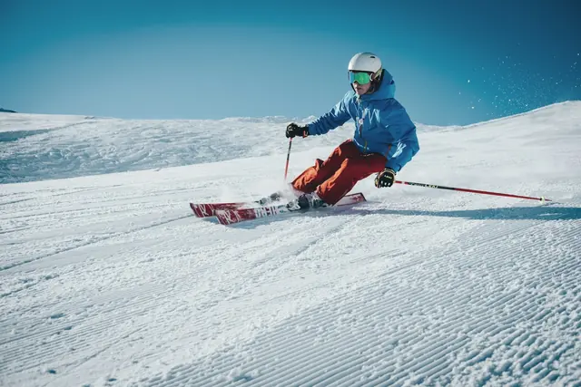 Skieur en virage sur une piste ensoleillée