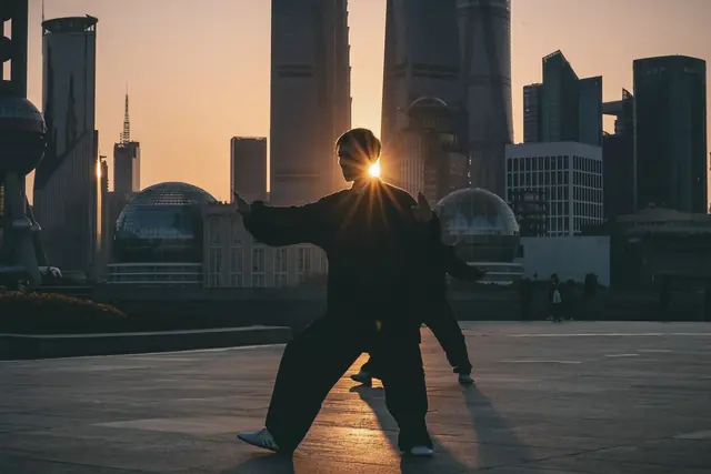Pratiquant de tai-chi au crépuscule en ville